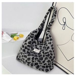 Détail du sac cabas en peluche léopard avec étiquette de marque et fausse fourrure