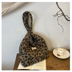 Gros plan du sac seau en fausse fourrure léopard sur une table en bois avec décor hiver