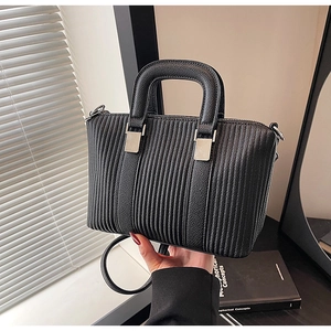 Close-up of black pleated bucket bag with vertical stripe texture and silver metal hardware