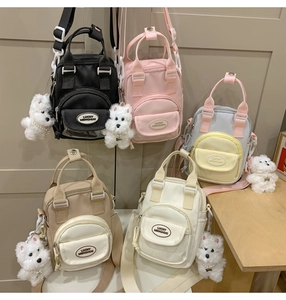 Close-up of candy-colored mini crossbody bags with cute plush dog charm accessories