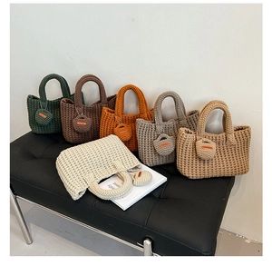 Detail view of colorful knitted bucket bags with handmade heart charms in various colors