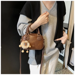 Brown vintage faux leather crossbody bag with a cute lion plush keychain and top handles