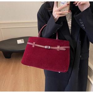 Close-up of burgundy frosted tote bag with metal buckles and soft suede texture
