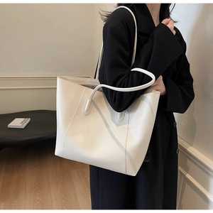 Detailed view of cream minimalist tote bag with fine stitching on sleek matte leather