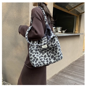 Détail d'un sac seau en peluche à motif léopard, fausse fourrure et étiquette tissée
