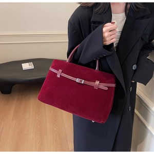 Close-up of a burgundy matte suede tote bag with elegant silver buckle and top handle