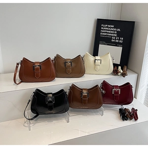Detailed view of six half-moon leather handbags in various colors with silver buckle detail