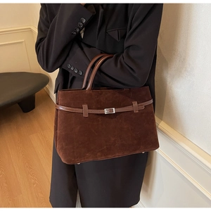 Detail of retro dark brown matte leather tote bag with silver buckle on a model