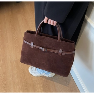 Close-up of vintage brown frosted leather tote bag with decorative buckle and stitching