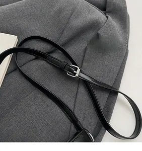 Close-up of sleek black leather adjustable shoulder strap with silver metal buckle detail