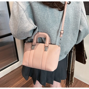Pink crossbody bucket bag featuring vertical striped texture and silver hardware