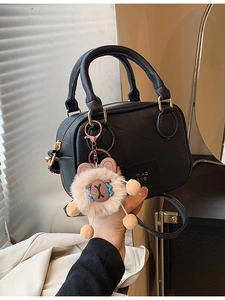 Black leather mini Boston bag with plush lamb charm and adjustable shoulder strap