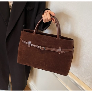 Detail of dark brown frosted tote bag with silver buckle and elegant leather handles
