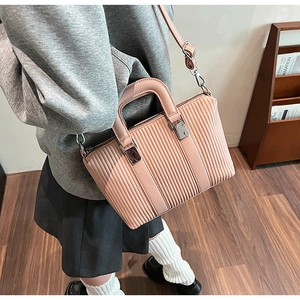 Detailed side view of a pleated bucket bag in dusty pink with adjustable strap