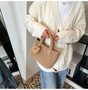 Detail of hand-knitted brown bucket bag with dense crochet texture and orange leather label