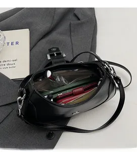 Interior view of black glossy leather underarm bag showing spacious storage for daily items