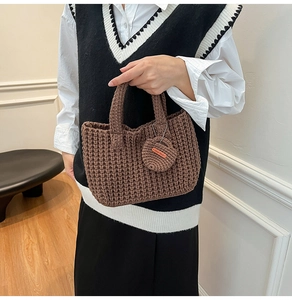 Detail view of brown knit tote bag featuring a round Hand Made tag and textured crochet