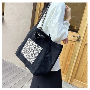 Detailed view of black corduroy tote bag with leopard print patch and large capacity