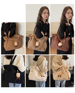 Dettaglio borsa tote in velluto a coste in cinque colori con ciondolo a tazzina