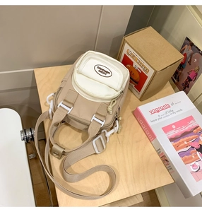 Detailed view of the multi-zipper khaki and off-white crossbody phone bag with strap