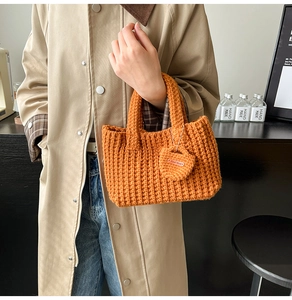 Detail of orange knitted bucket bag with Hand Made tag and vertical knit texture