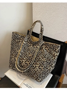 Stylish large leopard print canvas tote bag with shoulder straps on a leather chair