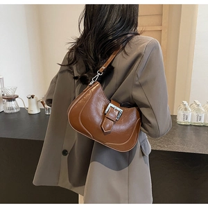 Detail of caramel brown retro leather Hobo bag with silver buckle and adjustable strap