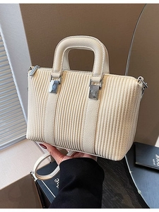 Chic cream-colored pleated handbag with silver hardware and adjustable shoulder strap