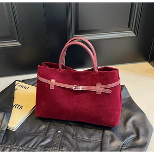 Close-up of burgundy frosted suede tote bag with leather strap and silver buckle detail