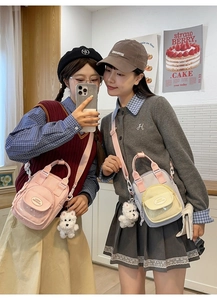 Close-up of pastel nylon crossbody bags with transparent card slots and plush charms