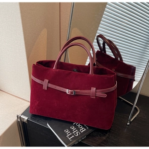Macro detail of wine red velvet tote bag with magnetic closure and silver metal buckle
