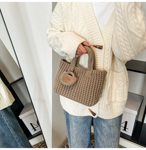 Detail of coffee brown chunky knit bucket bag with handmade tag and mini coin purse