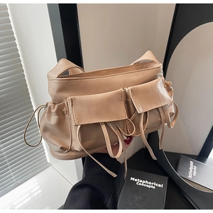 Detail shot of khaki PU leather baguette bag featuring retro flap pockets and drawstring accents