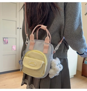 Detailed shot of a tricolor canvas bag featuring grey body, yellow pocket and pink straps