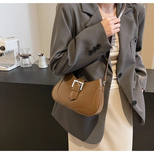 Detail of vintage brown half-moon shoulder bag with a silver metal buckle accent