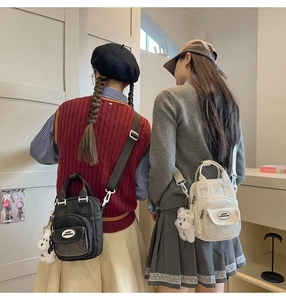 Dual shot of black and white mini crossbody bags with cute plush dog pendants