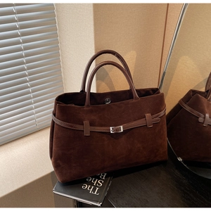 Detail of dark brown matte tote bag showing silver buckle and magnetic closure