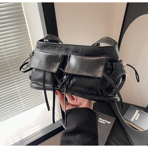Detail of black bow pleated bowling bag with dual front flap pockets and tassel drawstrings