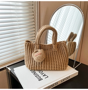 Detail of hand-knitted beige bucket bag showing square texture and Hand Made tag