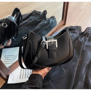 Detailed view of black crescent underarm bag with silver buckle and smooth leather texture