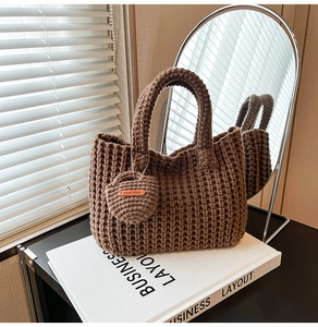 Detailed close-up of brown knit handbag texture with heart-shaped handmade charm tag