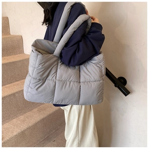 Chic light grey quilted puffer shoulder bag in matte nylon shown on a model