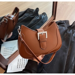 Detailed view of the brown caramel moon bag showing shiny leather and silver buckle