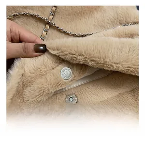 Détail d'un sac seau en fausse fourrure avec fermoir magnétique et bandoulière chaîne
