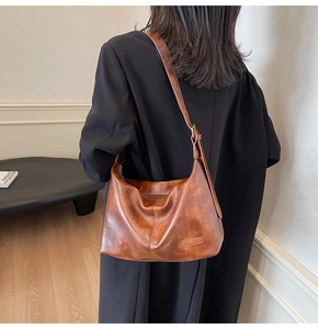 Sac cabas vintage en cuir marron vu de côté sur modèle avec bandoulière réglable