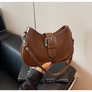 Detail shot of a dark brown retro moon bag featuring a large silver square buckle
