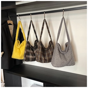Vista dettagliata di grandi borse hobo in pelliccia sintetica gialla, quadri e tweed grigio