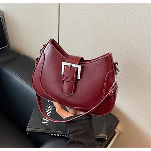 Detailed shot of burgundy hobo bag featuring glossy finish and silver buckle closure
