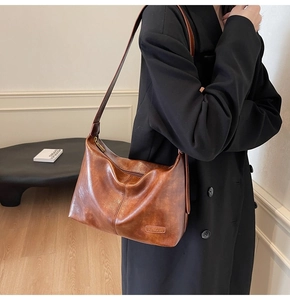 Vue latérale d'un sac cabas vintage en cuir ciré marron porté par un mannequin