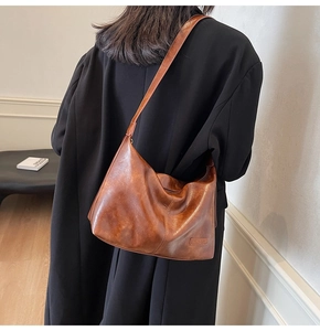 Gros plan d'un grand sac cabas vintage marron avec texture cuir lisse porté par un mannequin